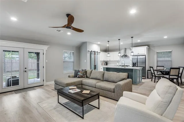 a living room with furniture kitchen view and a wooden floor