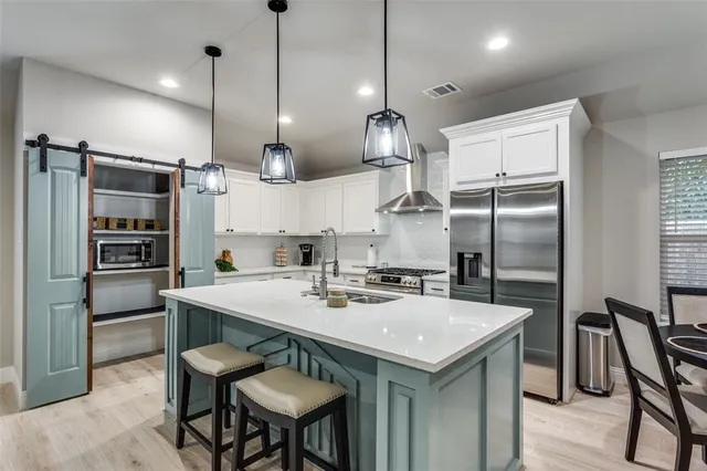 a kitchen with refrigerator cabinets and wooden floor