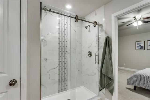 a bathroom with a shower and a glass door