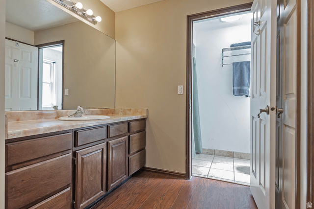 3310 Creek Road Salt Lake City, UT 84121 - Photo 24 of 49 Vanity area featuring a wood-finish cabinet with multiple storage drawers and doors, a beige countertop with an integrated sink, and an overhead vanity light fixture