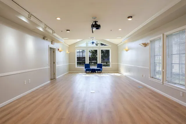 a view of a livingroom with furniture a ceiling fan and hardwood floor