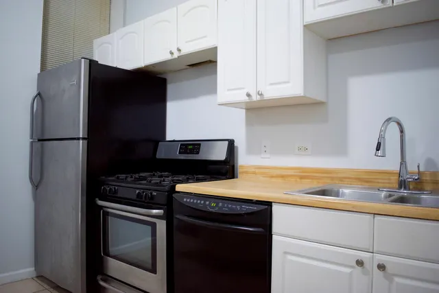 a kitchen with stainless steel appliances granite countertop a stove a refrigerator and a sink