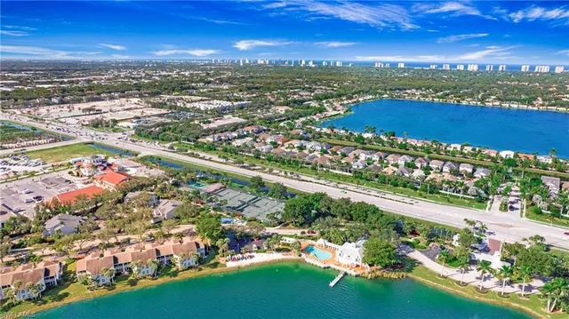 an aerial view of residential houses with outdoor space and trees