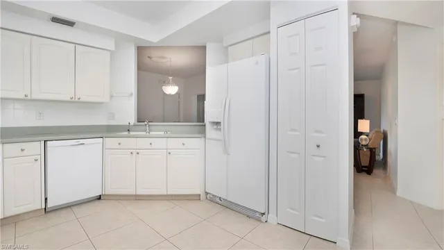 a view of cabinets and walk in closet with white walls