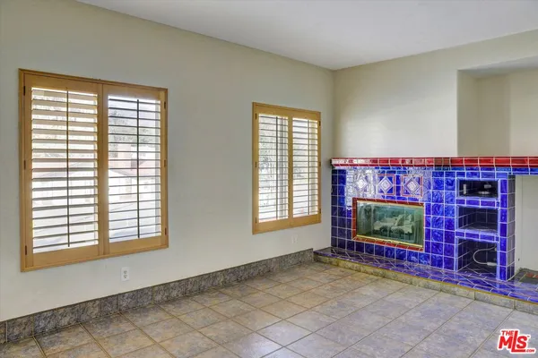 an empty room with windows fire place and fireplace