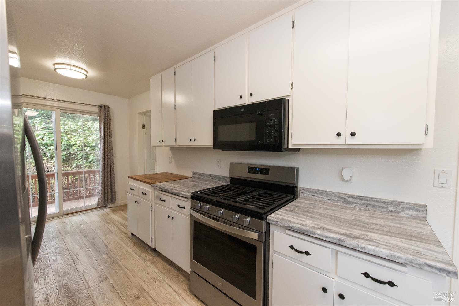 8650 Mirabel Road Forestville, CA 95436 - Photo 7 of 42 a kitchen with granite countertop a stove and a wooden floors