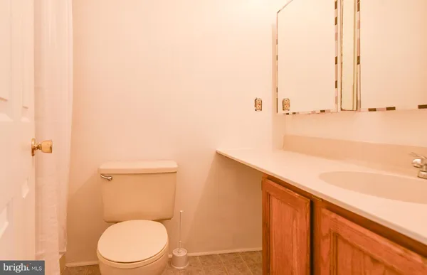 a bathroom with a toilet a sink and vanity