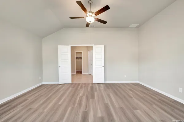a view of empty room with wooden floor