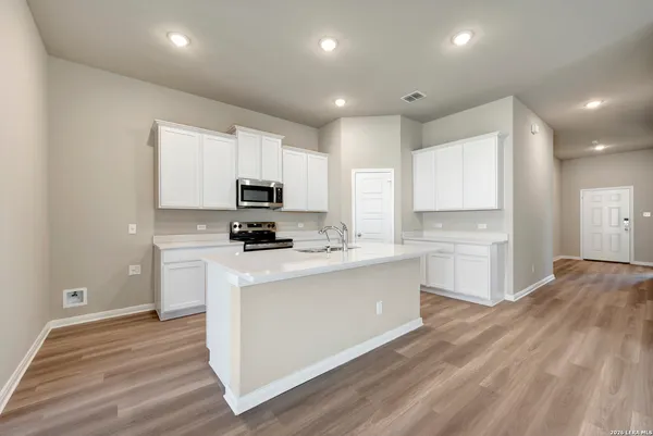 a kitchen with stainless steel appliances granite countertop a stove a sink and a refrigerator