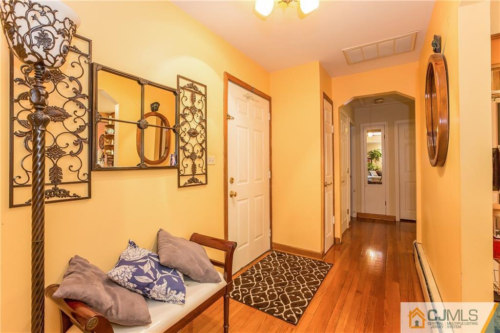 190 Normandy Road Edison, NJ 08820 - Photo 3 of 25 a view of a hallway to a livingroom with wooden floor and a chandelier