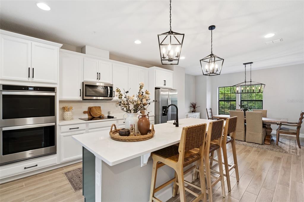 1230 Spotted Sandpiper Loop Winter Springs, FL 32708 - Photo 24 of 52 a kitchen with stainless steel appliances a dining table chairs stove and microwave