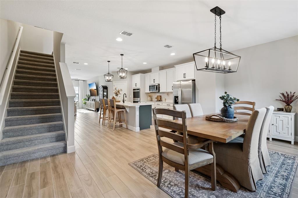 1230 Spotted Sandpiper Loop Winter Springs, FL 32708 - Photo 27 of 52 a dining room with wooden floor a chandelier a wooden table and chairs