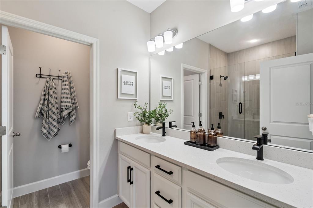 1230 Spotted Sandpiper Loop Winter Springs, FL 32708 - Photo 38 of 52 a bathroom with a double vanity sink a shower and a mirror