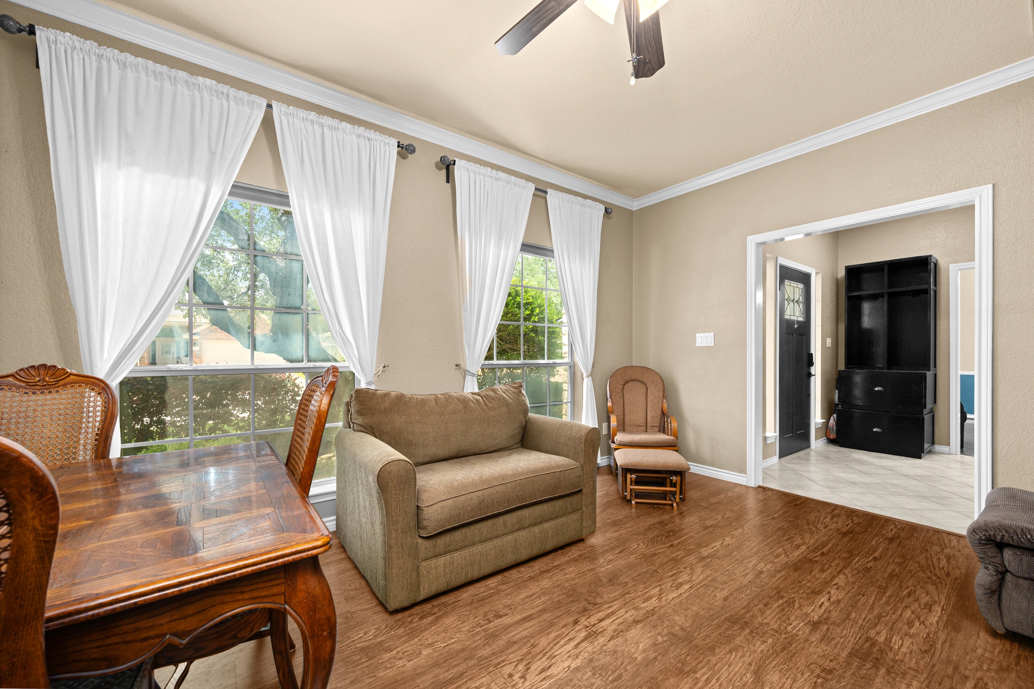 108 Thornwood Road Georgetown, TX 78628 - Photo 8 of 40 Natural light streams into this welcoming living area, featuring rich wood flooring and subtle crown molding.