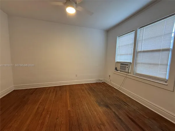 a view of a room with wooden floor and window