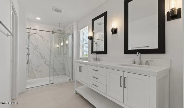 a bathroom with double sink and a mirror