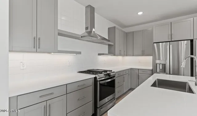 a kitchen with stainless steel appliances a stove a refrigerator and cabinets