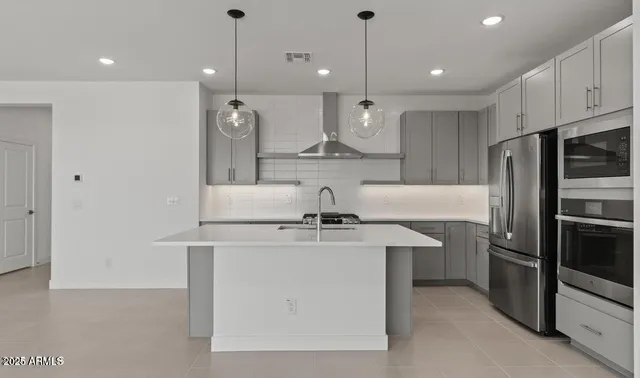 a kitchen with kitchen island a stove a sink and a refrigerator