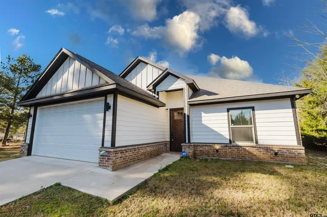 a front view of a house with yard and garage