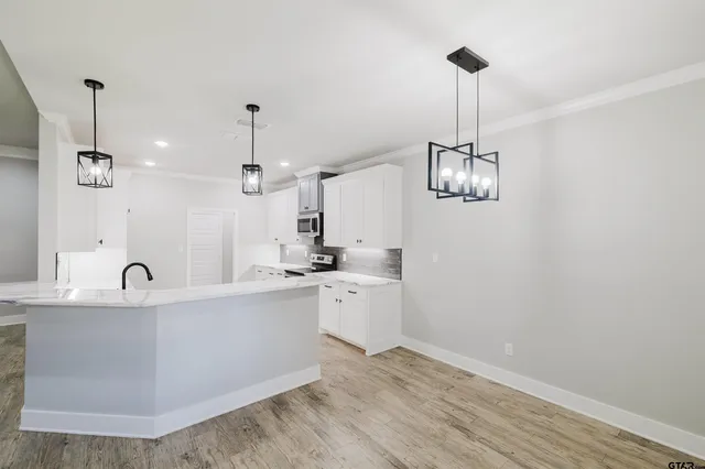 a kitchen with a sink and chandelier