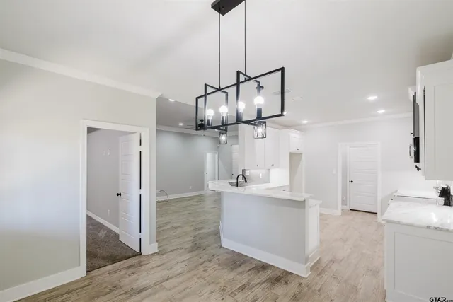 a kitchen with stainless steel appliances granite countertop a sink a stove a refrigerator and island with wooden floor