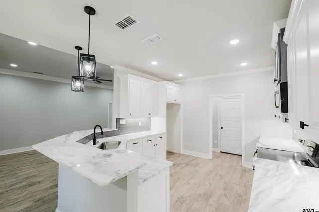 a kitchen with granite countertop a sink stove and cabinets