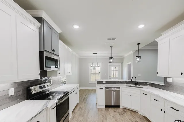 a kitchen with granite countertop white cabinets and black appliances