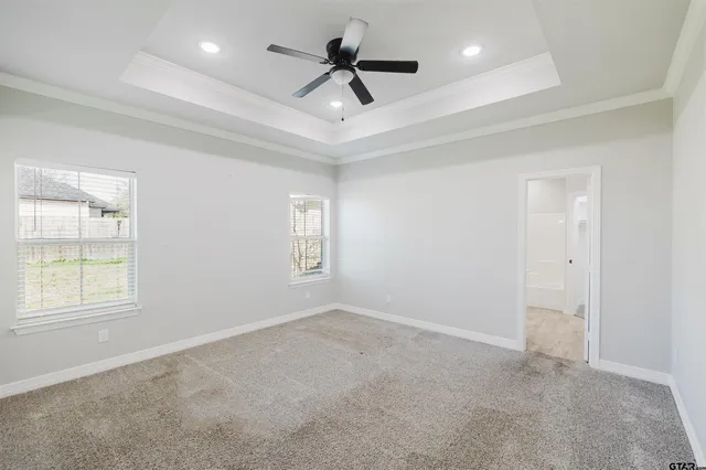 an empty room with windows and ceiling fan