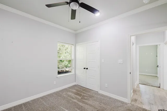 an empty room with a window and a fan