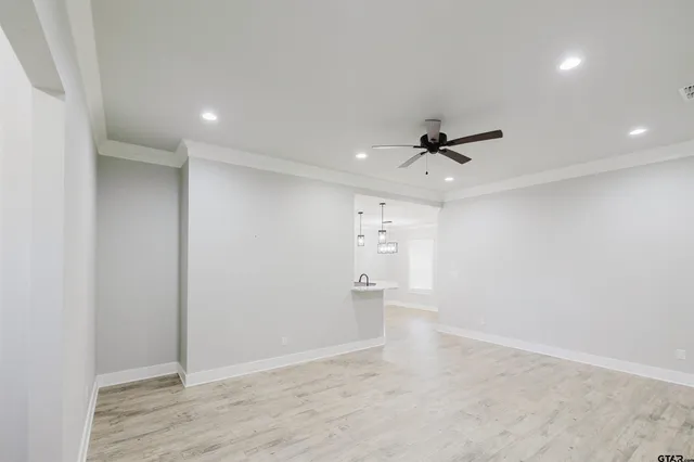 wooden floor in an empty room with a ceiling fan
