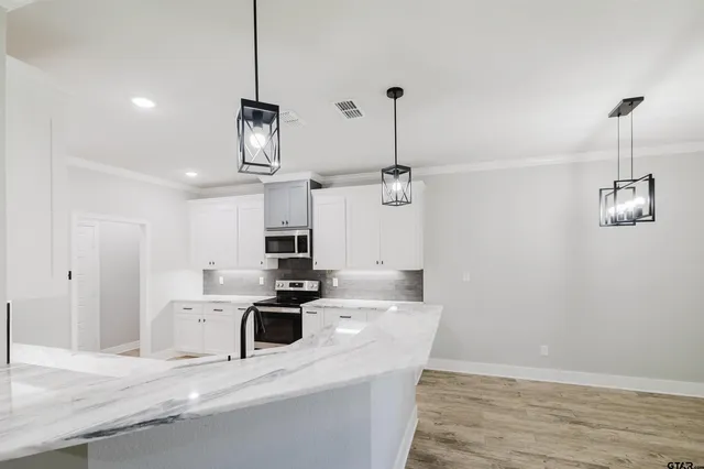 a kitchen with kitchen island a sink a stove a microwave and a refrigerator