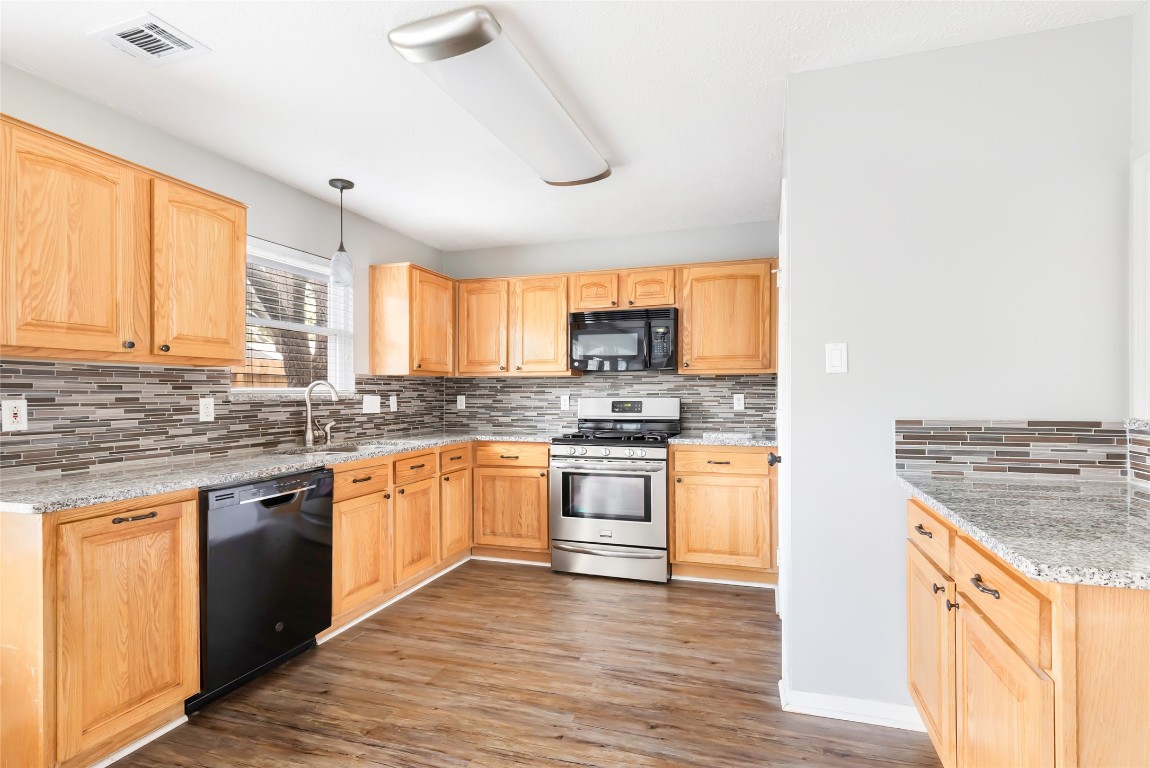 31315 Copperleaf Drive Spring, TX 77386 - Photo 17 of 34 a kitchen with stainless steel appliances granite countertop hardwood floor sink stove and wooden cabinets
