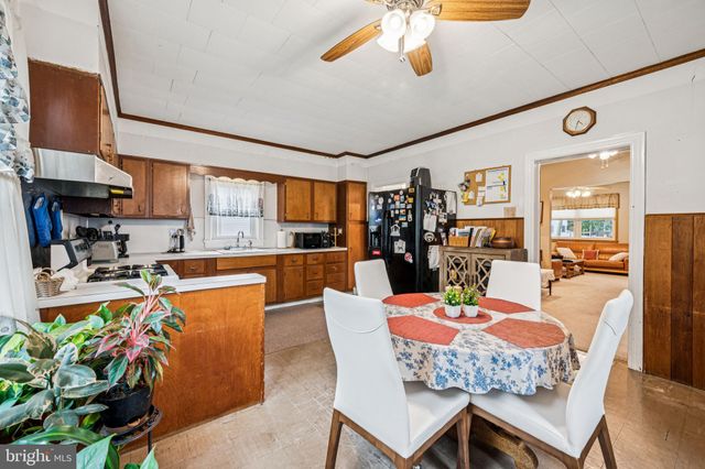 a dining room with furniture a kitchen view and a chandelier