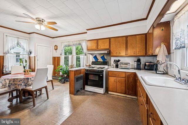 a kitchen with sink a stove and chairs