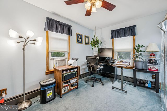 a view of a workspace with furniture and a window