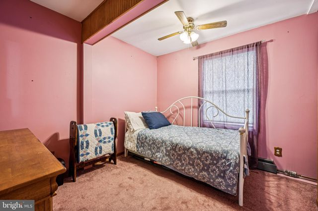 a bedroom with a bed and a dresser with the shoe rack