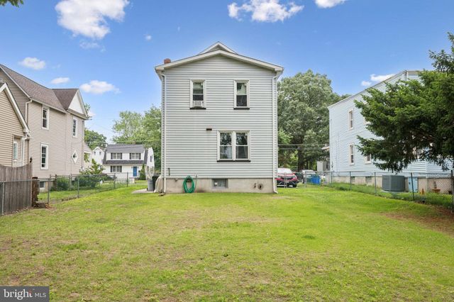 a view of a house with a big yard and large trees
