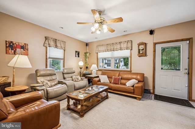 a living room with furniture ceiling fan and a window