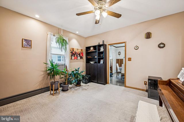a view of a livingroom with a potted plant a ceiling fan and a large window