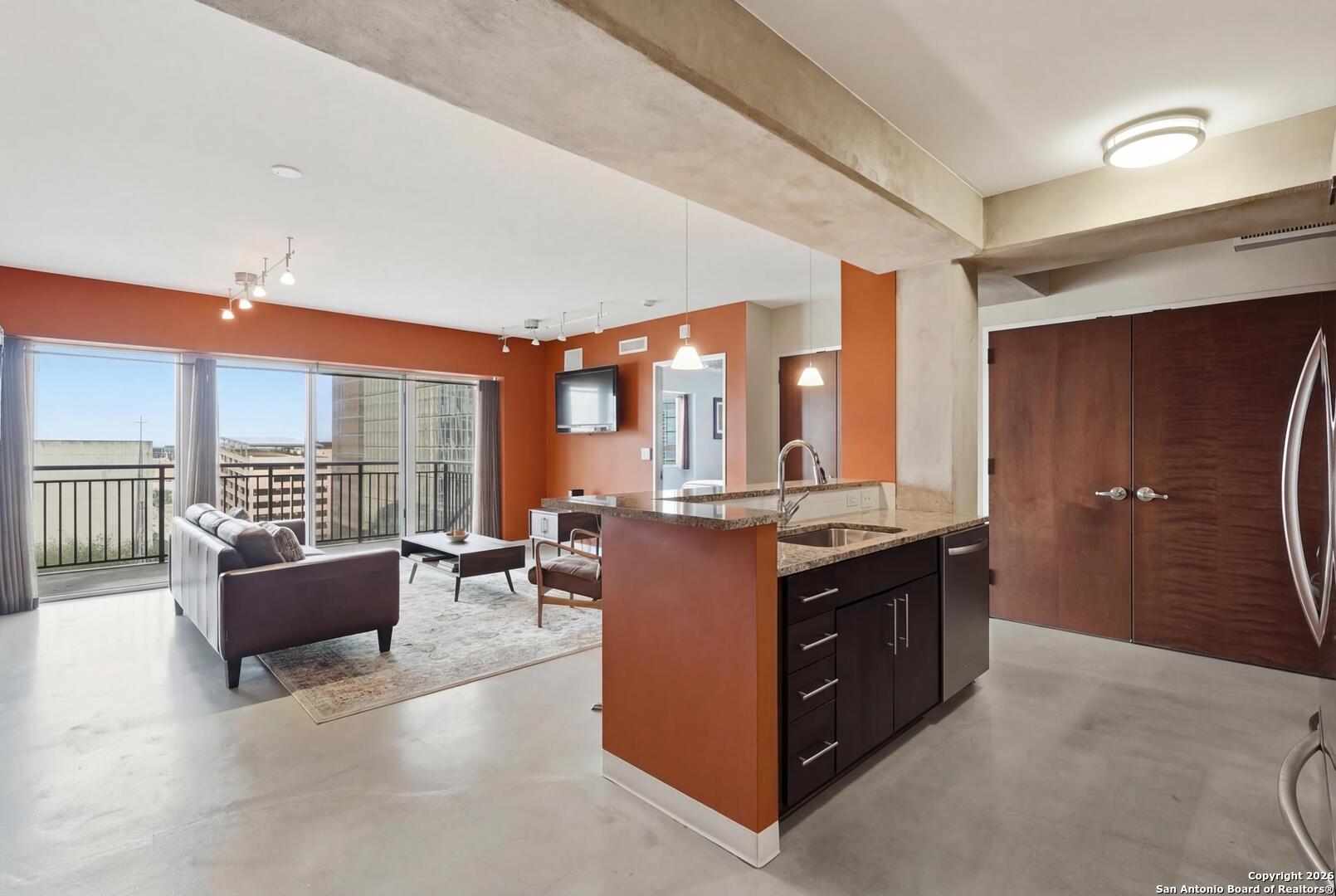 800 Brazos Street, Unit 1103 Austin, TX 78701 - Photo 9 of 26 a large kitchen with kitchen island a large counter top space a sink a window and stainless steel appliances