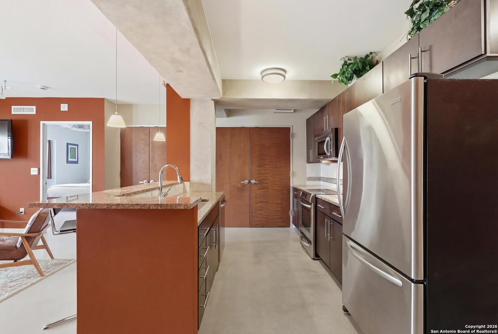 800 Brazos Street, Unit 1103 Austin, TX 78701 - Photo 10 of 26 a kitchen with stainless steel appliances a refrigerator and a stove