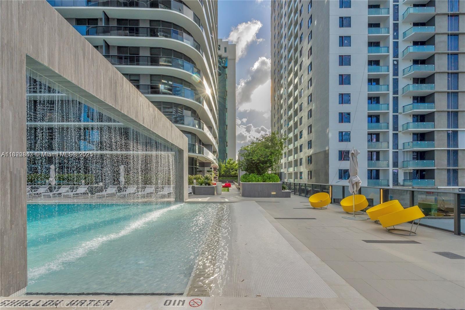45 Southwest 9th Street, Unit 3403 Miami, FL 33130 - Photo 24 of 27 a view of a swimming pool with a lounge chairs in front of house