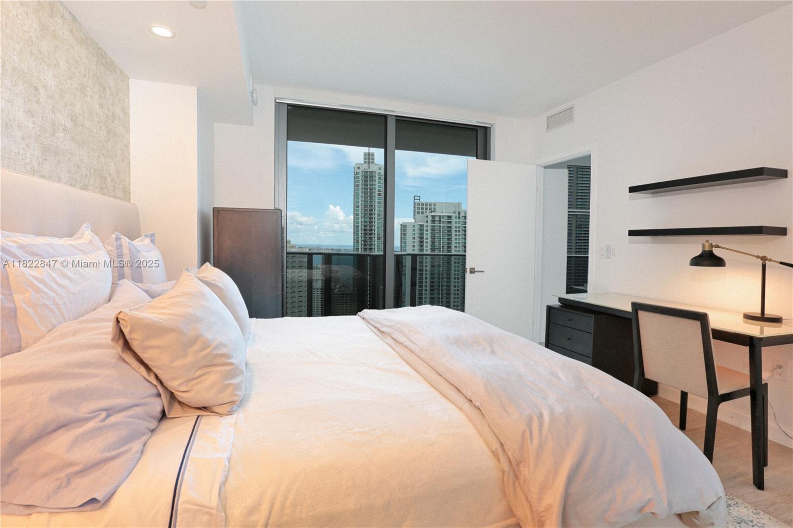 45 Southwest 9th Street, Unit 3403 Miami, FL 33130 - Photo 8 of 27 a bedroom with a bed and lamp with the chair