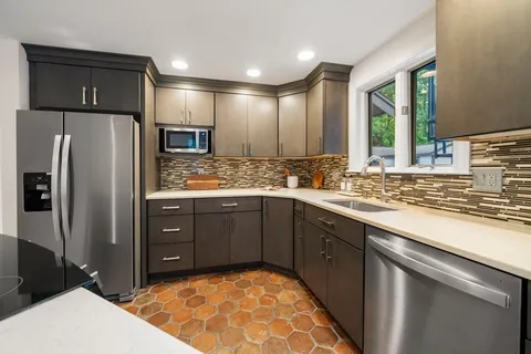 a kitchen with stainless steel appliances granite countertop a sink stove and refrigerator