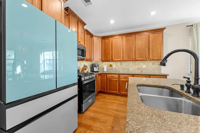 a kitchen with kitchen island granite countertop a sink cabinets and stainless steel appliances