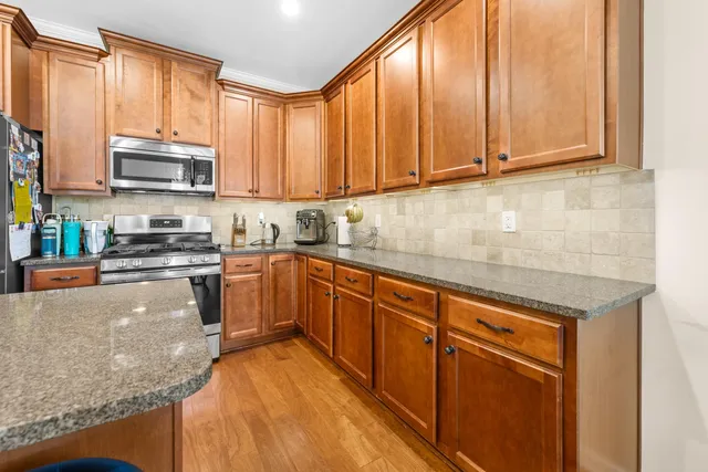 a kitchen with stainless steel appliances granite countertop a stove a sink and a microwave