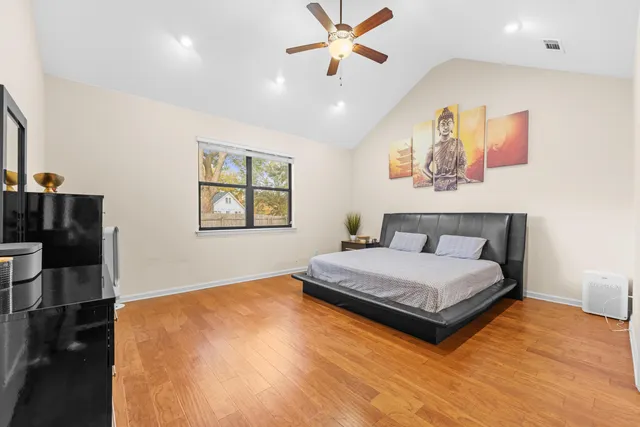 a bedroom with a large bed and a chandelier