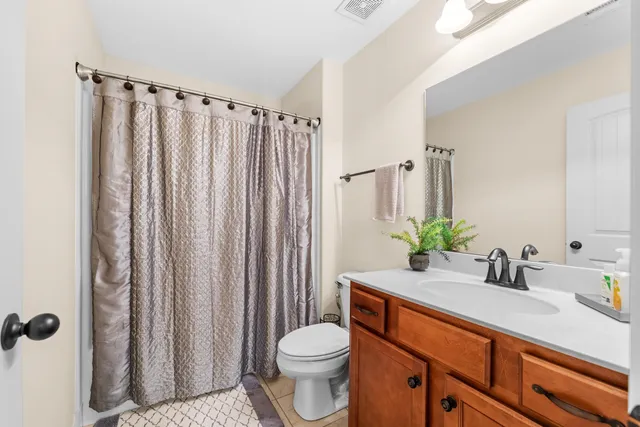 a bathroom with a sink a toilet and shower curtain