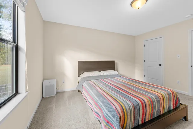 a bedroom with a bed and a window