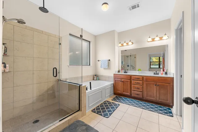 a large bathroom with a glass door shower a sink and a mirror